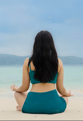 Persona meditando en la playa